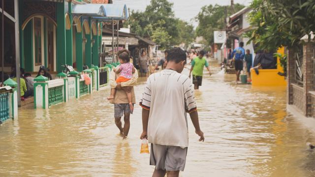 Ilustrasi rumah kebanjiran dengan genangan air, tips aman membersihkan rumah setelah banjir